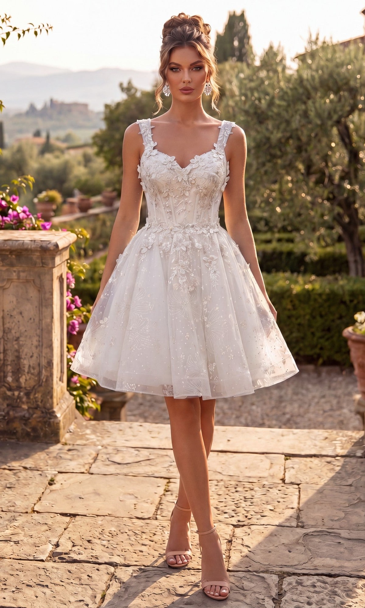 Wearing the Chicas C372 Short Homecoming Dress in Off White, a woman stands outdoors on a stone path surrounded by greenery and flowers. The flattering fit-and-flare silhouette and delicate corset bodice of this sleeveless lace dress with floral details perfectly complement the romantic setting.